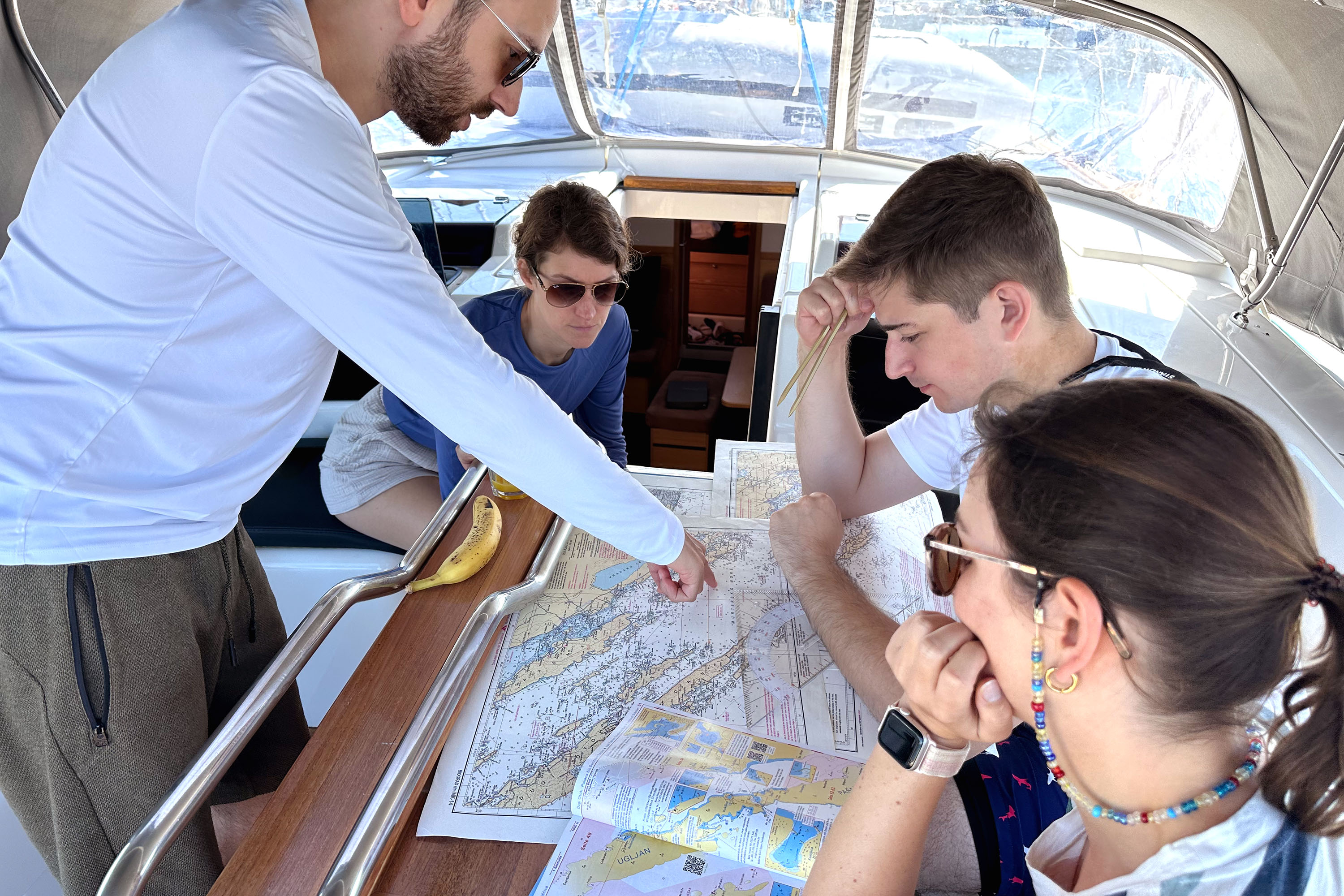 Crew beim Navigieren mit Seekarten